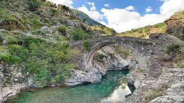 Bridge in Corsica France over beautiful turquoise water